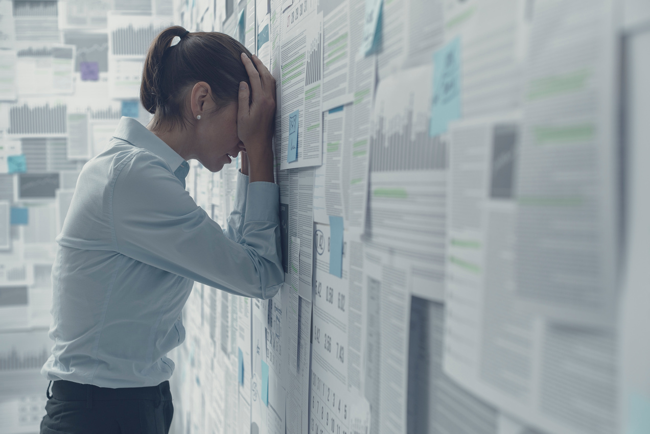 Stressed Woman in a Room Covered with Paperwork  